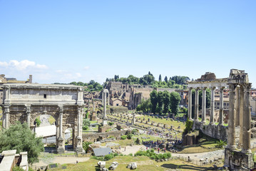 Fototapeta na wymiar Rome, ruins of the Imperial forums of ancient Rome. Arch of Septimius Severus and Temple of Saturn