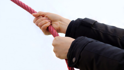 A hand holding a red rope