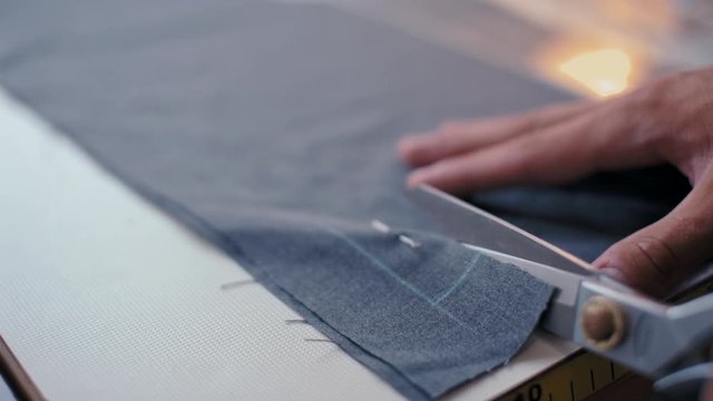 Nice Cloth is Cutting by Professional Scissors by Tailor Man in the Fashion Clothing Studio