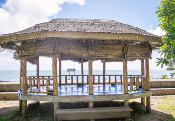 Open-sided beach hut or fale with woven palm leaf roof by waterfront near Pula Cave Pool, Upolu Island, Samoa, South Pacific © corners74