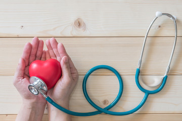 Healthcare medical insurance and World heart health day concept with red heart on woman's hands...