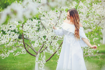 Obraz na płótnie Canvas Close up romantic portrait of beautiful elegant woman in blossom spring trees.