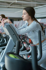 Young woman running on treadmill. Beautiful young woman in gym. Running in sport club