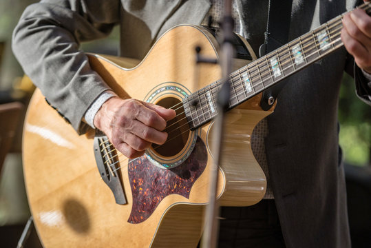 Closeup of man's hands playing acoustic guitar. Musical concept.