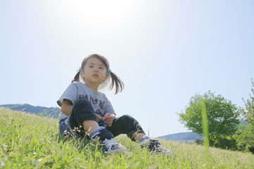 芝の上に座る幼児(3歳児)