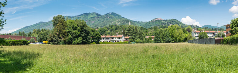 Fototapeta na wymiar Varese, Italy. Panoramic view towards the mountain behind the city, Campo dei Fiori (regional park) and the small village of Sacro Monte (UNESCO site); in the middle the remains of the Torre di Velate