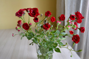 Bouquet of roses in a vase on the table. Composition of flowers. Floristic