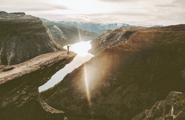 Tourist on Trolltunga cliff edge in Norway adventure travel lifestyle active vacations outdoor...