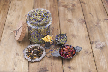 Assorted dried flowers and tea on a wooden background. Natural health. Aromatherapy. Free space for text. Copy space