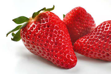 Closeup photo of three strawberries isolated on white background.
