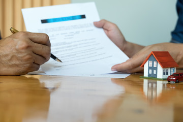 Hands holding small house after signing contract,concept for real estate,Insurance and safety concept with house protected by hands, moving home or renting property