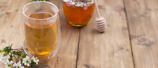 tea with herbs and honey on a wooden background and flowers. Natural health. Copy cpace.