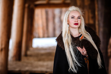 Beautiful young woman holding a viking with blond hair. Image of Historical figure