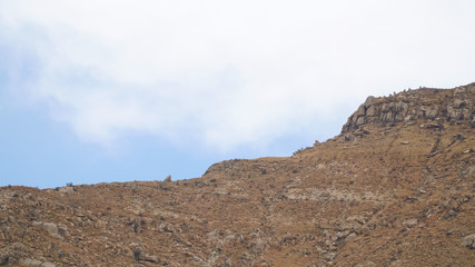 Mountain peak with some clouds and clear blue sky