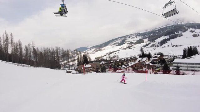 A little girl skiing in mountains, action camera footage