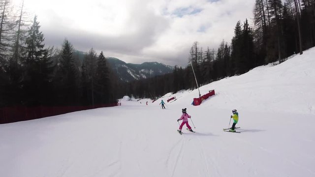 A little girl skiing in mountains, action camera footage