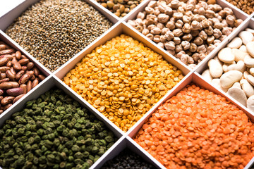 Indian Beans,Pulses,Lentils,Rice and Wheat grain in a white wooden box with cells, selective focus.