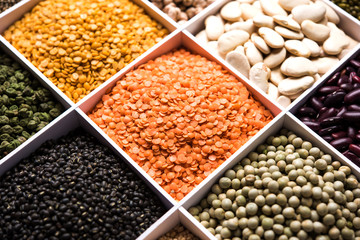 Obraz premium Indian Beans,Pulses,Lentils,Rice and Wheat grain in a white wooden box with cells, selective focus.