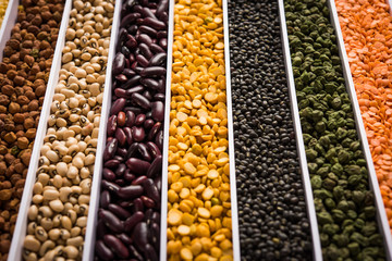 Indian Beans,Pulses,Lentils,Rice and Wheat grain in a white box with cells or strips, selective focus.
