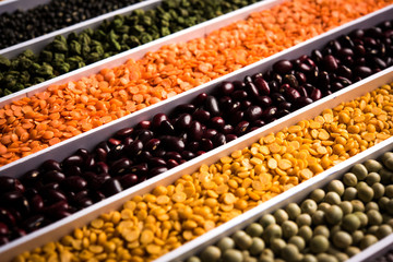 Indian Beans,Pulses,Lentils,Rice and Wheat grain in a white box with cells or strips, selective focus.