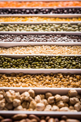 Indian Beans,Pulses,Lentils,Rice and Wheat grain in a white box with cells or strips, selective focus.