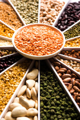 Indian Beans,Pulses,Lentils,Rice and Wheat grain in a white Sunburst or sun rays shape designer container , selective focus.