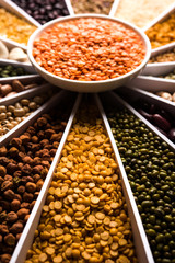 Indian Beans,Pulses,Lentils,Rice and Wheat grain in a white Sunburst or sun rays shape designer container , selective focus.