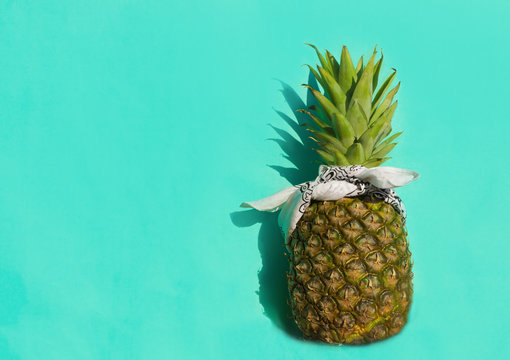 Pineapple in  white bandana on a blue background.Summer minimalism, close up