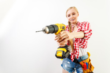 Woman using drill on wall