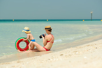 Toddler boy on beach with mother