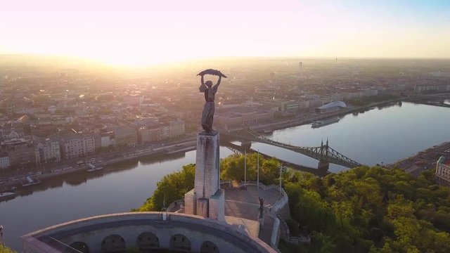 Budapest, Hungary - 4K aerial footage of flying around Statue of Liberty on Gellert Hill with Budapest skyline at sunrise