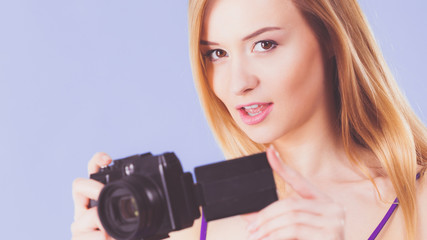 Blonde woman with camera on blue