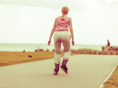 Fit woman on roller skates riding outdoor