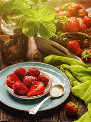 Still-life with strawberries. Natural fresh ripe strawberry on a plate. Still life in a rustic style.