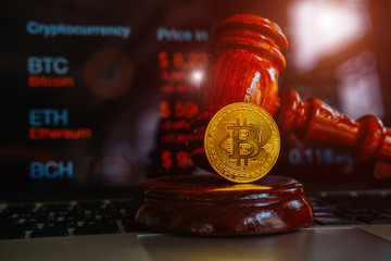 Law or auction gavel and bitcoins on a wooden desk, dark background, gavel and bitcoin symbol on brown table with copyspace. Bitcoin Currency Technology Business Internet Concept.
