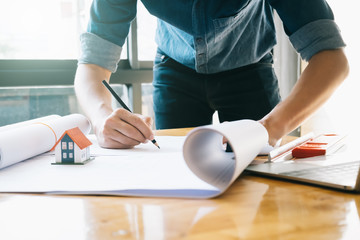 Architect or engineer working in office with blueprints,engineer inspection in workplace for architectural plan,sketching a construction project ,selective focus,Business construction concept.