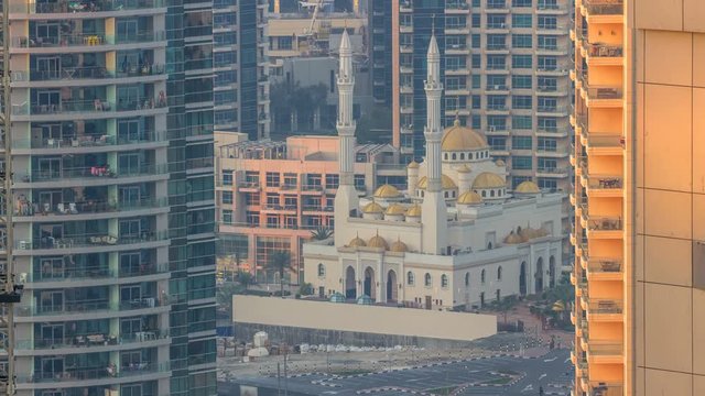 Al Raheem mosque between skyscrapers timelapse on the marina walk in Dubai Marina, Dubai, UAE.