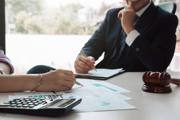 Consultation between business and lawyer about the tax laws discussing a contract agreement to pay taxes economically to the government in accordance with the national law.