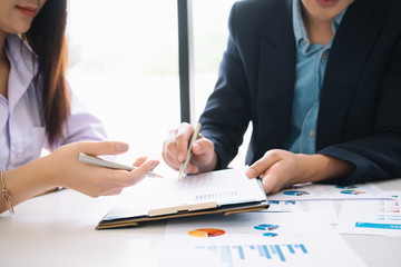 Business man supervising and secretary to execute business plan and consultant analyzing company annual financial report balance sheet statement working with documents graphs. Audit and consultant