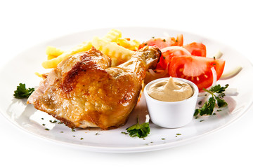 Roast chicken leg with french fries on white background