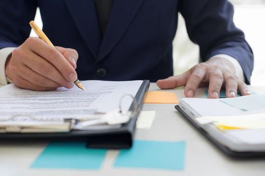 Close up business man reaching out sheet with contract agreement proposing to sign.Full and accurate details, individual who owns the business sign personally,director of the company, solicitor.