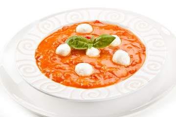 Tomato soup with mozzarella on white background