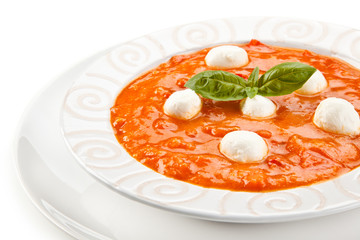 Tomato soup with mozzarella on white background
