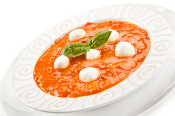 Tomato soup with mozzarella on white background