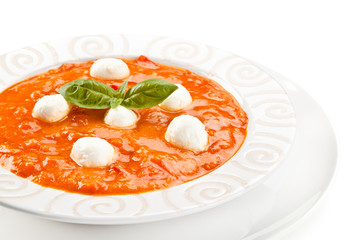 Tomato soup with mozzarella on white background