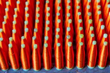 Naklejka premium Top View Group of Silk Spools with Red Silk Thread Yarn for Weaving Machine to make Thai Fabric Silk
