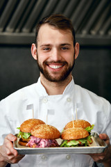 Chef With Burgers In Restaurant Kitchen