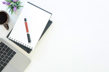 Workspace laptop computer, notepad paper, pen and coffee cup on office work table with top view.