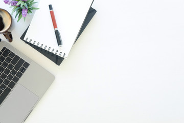 Workspace laptop computer, notepad paper, pen and coffee cup on office work table with top view.