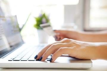 Shopping online concept, woman using laptop computer and holding credit card.